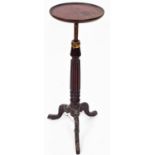 An early 20thC mahogany jardiniere stand, the circular top raised on a reeded stem, terminating in
