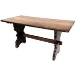 A 20thC oak plank top refectory table, with oblong top on shaped legs, joined by a horizontal