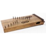 A 19thC stringed tribal style zither type instrument, of square block form with lyre carving and