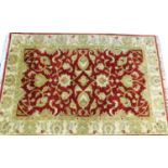 A modern Indian bordered woollen rug in red and gold, 163cm x 122cm.