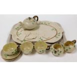 An early 20thC Belleek part tea service, decorated with clover, comprising teapot with bark handle