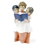 A 20thC Lladro figure of three choir boys singing, one holding music book, printed marks beneath,