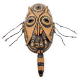 An African tribal mask, in black and orange with elongated features, and lower handle, 46cm high.