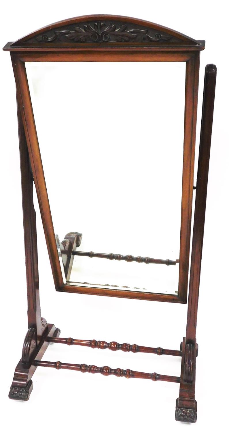 An early 19thC mahogany cheval mirror, of rectangular form with a scroll carved fret, on a turned