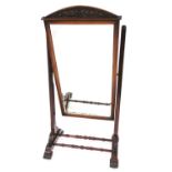 An early 19thC mahogany cheval mirror, of rectangular form with a scroll carved fret, on a turned