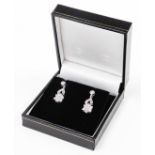 A pair of 18ct white gold diamond daisy drop earrings, the drop element with two row twist design of