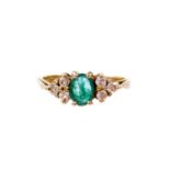 A 9ct gold dress ring, with central green emerald, with three CZ stones to each side, in claw