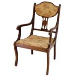 An Edwardian mahogany salon carver chair, with overstuffed back and seat, in floral material, and an