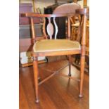 An Edwardian corner chair, with marquetry fret decoration, a cream velvet seat on H stretcher,