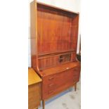 A teak display cabinet, the top with three adjustable shelves, with a bureau type enclosed section