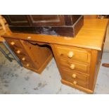A pine twin pedestal desk or dressing table, each pillar with four drawers, on plinth base, 76cm