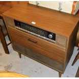 A Grudig stereogram, in a faux teak case with central dial and speakers, on splayed feet, 82cm high,