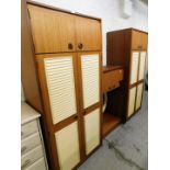 A teak 1970's style bedroom suite, comprising two two door wardrobes, and a wall mountable