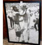 A framed print of Bobby Moore and Pele, in black frame.