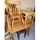 A group of furniture, to include an oak dining table, two pine kitchen chairs, a nest of two