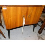 A teak 1960's/70's side cabinet, with arrangement of sections and two drawers, on black tapering