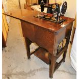 A Jones sewing machine in oak stand, enclosed in a mahogany tailors work stand, with compartment