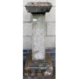 A composite bird bath, on plinth base, with tapered stem and small bowl. (AF)