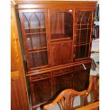 A yew finish display cabinet, with open shelves flanked by astragal glazed doors, with a fall to the