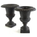 A pair of cast iron Campana type urns, each with a gadrooned border, part fluted body and square