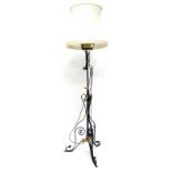 A black painted and gilt wrought iron standard lamp, with oil lamp fitting to the top and a shade,