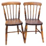 A pair of 19thC spindle back kitchen Windsor chairs, each with a solid elm seat, on turned