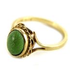 A 9ct gold dress ring, set with single green stone, in rub over setting, with rope twist border,