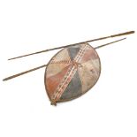 A tribal leather shield, decorated in iron red, black, cream, etc., possibly Masai, 110cm x 66cm,