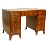 A mahogany kneehole desk, the rectangular top with a brown leather inset, above nine drawers, each