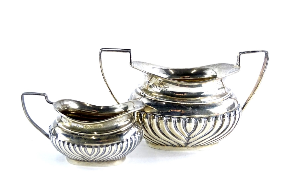 An Edwardian silver two handled sugar bowl, with part fluted decoration, Birmingham 1900, and a