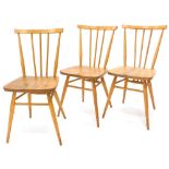 A set of three light coloured Ercol stick back chairs, each with a solid seat on turned tapering