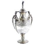 A small two handled silver urn shaped trophy and cover, decorated with flowers, leaves, etc., the