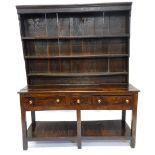 An 18thC oak dresser, the raised back with three plate shelves, the base with one short and two long