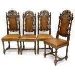 A set of four oak dining chairs, each carved with leaves and a bird crest, with a padded brown