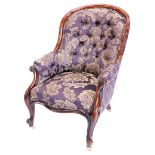 A Victorian mahogany showframe armchair, upholstered in maroon and gold floral fabric, on cabriole