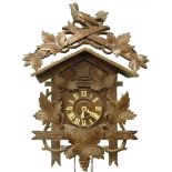 An early 20thC Black Forrest cuckoo clock, with a leaf and bird carved crest, the dial applied