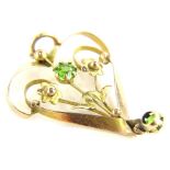 An Art Nouveau pendant, set with two peridots, each in claw setting, on twist framed and floral