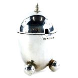 An Art Deco bullet shaped silver mustard pot, with a turned finial and three bun feet, Birmingham