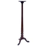 A mahogany plant stand, with a circular dish top on a leaf carved fluted column and tripod base,