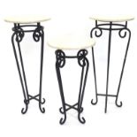 A pair of wrought iron and marble plant stands, each with a circular top of tapering form, 80cm