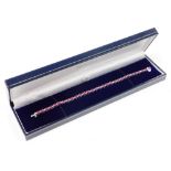 A ruby and diamond line bracelet, set with thirty oval cut rubies, each 3.8mm x 3mm x 1.2mm,