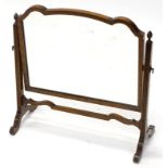 A mahogany swing frame dressing table mirror, the shaped plate on reeded tapering supports, with