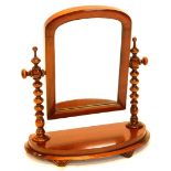 A Victorian mahogany bow fronted dressing table mirror, with arch plate on bobbin turned supports,