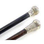 An ebonised walking stick, with silver collar with overall engraved decoration, and another