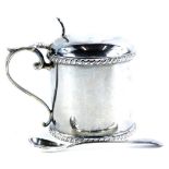 A late Victorian silver drum shaped mustard pot, with blue glass liner and gadrooned border,