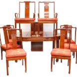 An oriental hardwood extending dining table, the top with D shaped ends and with a carved frieze