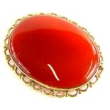 A 9ct gold framed oval agate brooch, with orange agate to centre, with pleated design frame, stamped