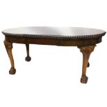 An early 20thC mahogany extending dining table, the oval top with a rope twist carved border, on