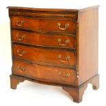 A mahogany chest of drawers in George III style, with a cross banded top and a moulded edge above