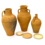 Three continental unglazed terracotta vessels, each of tapering form, with bases, the largest 62cm